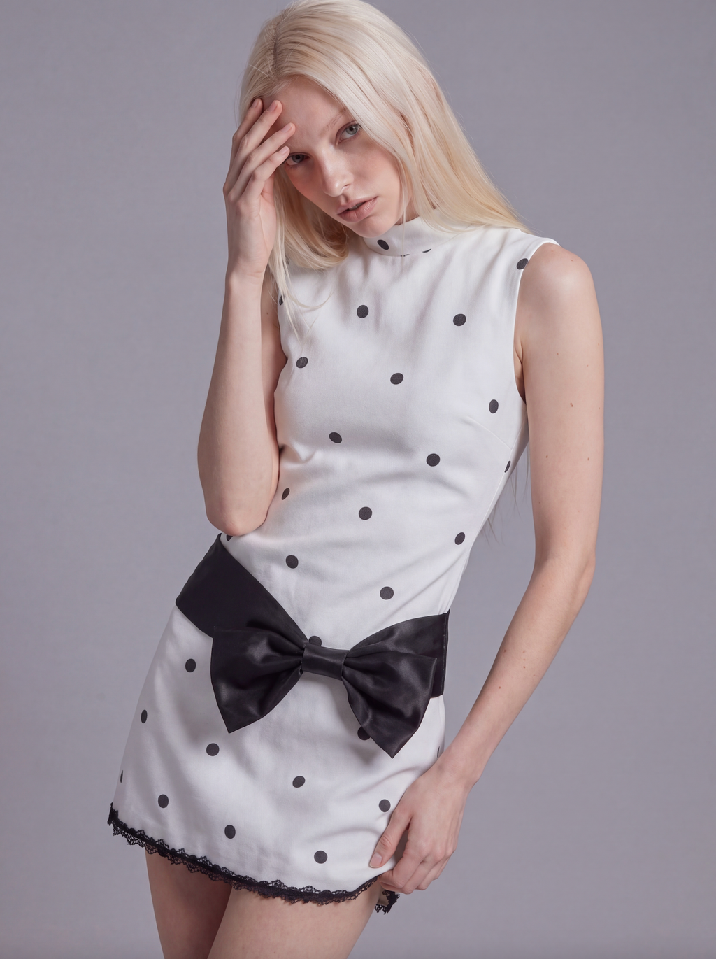 Sleeveless Polka Dot Mini Dress with Mock Neck and Satin Bow Waist Detail