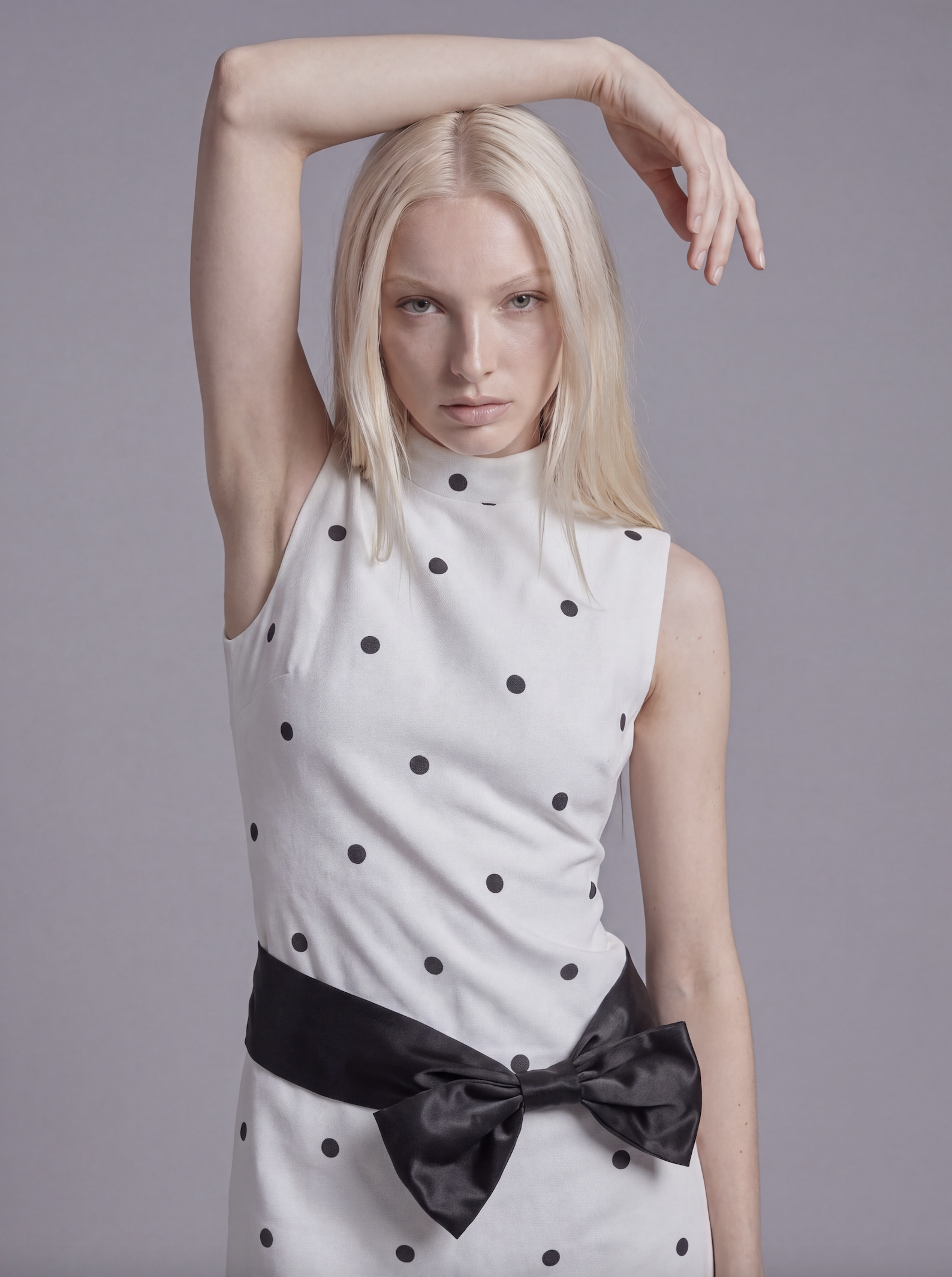 Sleeveless Polka Dot Mini Dress with Mock Neck and Satin Bow Waist Detail